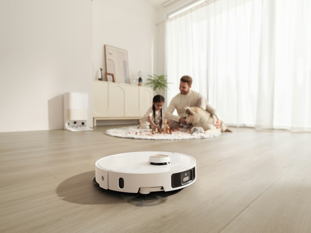 Services A Dreame robot mop and vacuum combo cleans a bright modern living room as a family enjoys time with their dog.